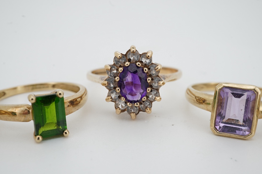 Five gem-set rings, comprising: three rings set with peridots and, one ring set with an amethyst, and one designed as a cluster of amethyst and rock crystal, each mounted in 9ct gold, sizes N-U, each with British hallmar